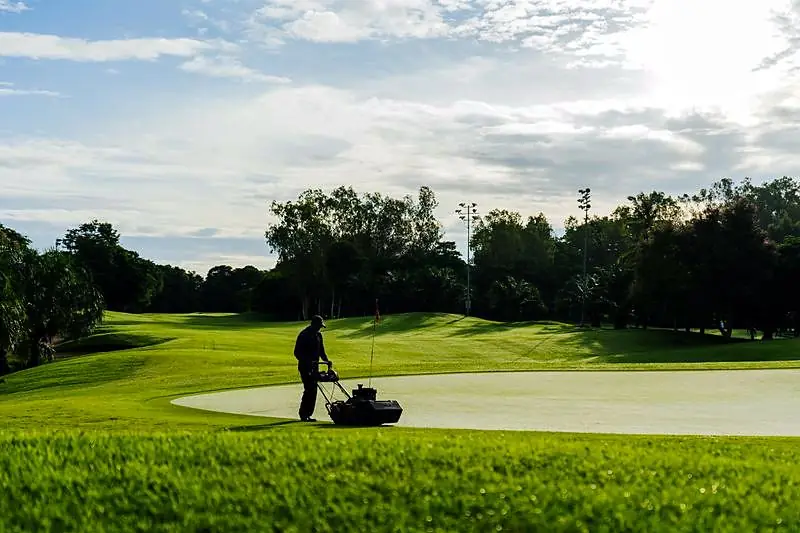 Professionnel tondant un green de golf