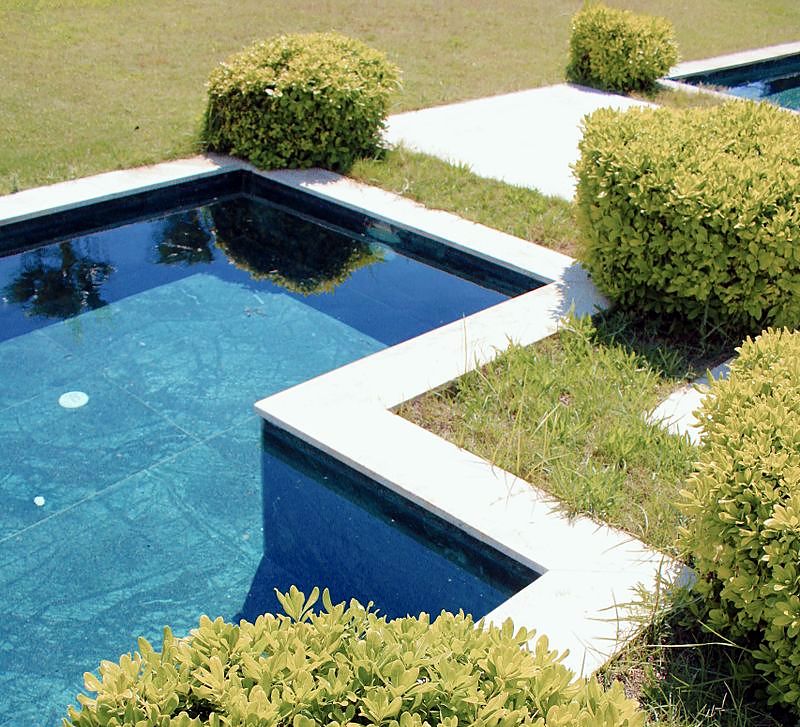 Jardin moderne avec bassin géométrique, haies taillées et pelouse